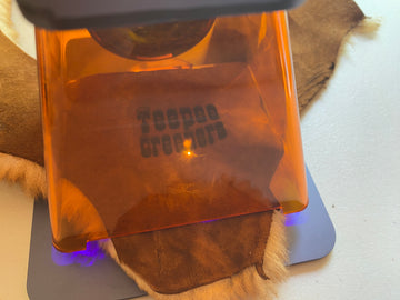Laser engraving a Teepee Creeper slipper logo on sheepskin